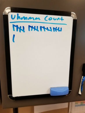 Small desktop whiteboard with tally marks for an "um" count on sales calls